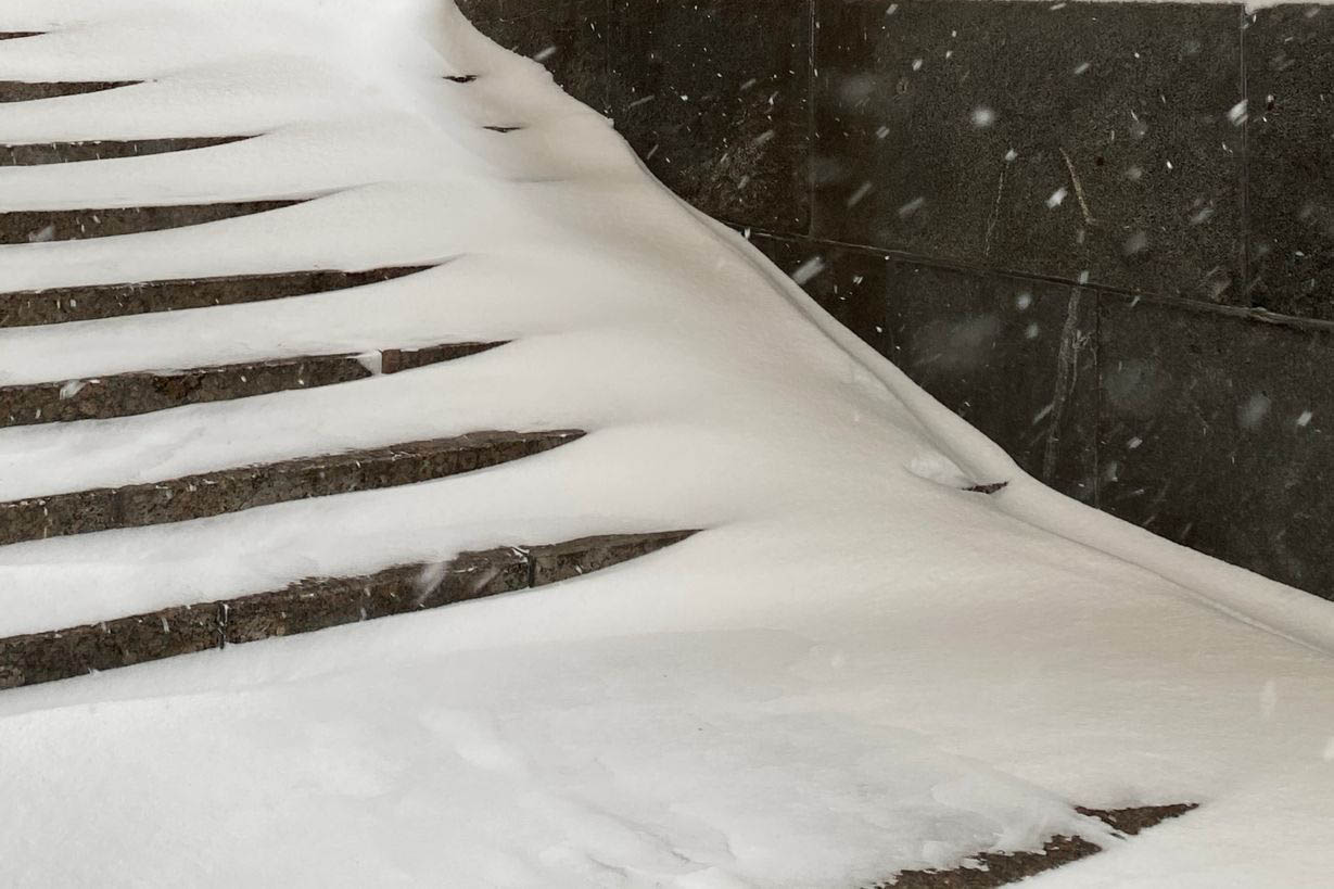 Stairs partially covered by snow.
